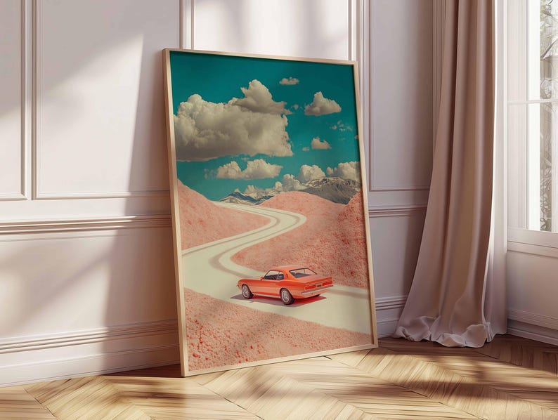 K&ouml;nnte beinhalten: Gerahmter Kunstdruck mit einer surrealen Landschaft, einer kurvenreichen Stra&szlig;e und einem orangefarbenen Oldtimer. Der Himmel ist t&uuml;rkis mit wei&szlig;en Wolken. Die H&uuml;gel sind rosa und erzeugen eine traumhafte Szene.