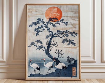 May include: Framed Japanese-style art print featuring a vibrant orange sun, a dark blue tree, and three white cranes with red accents. The artwork has a serene, nature-inspired theme, with a light blue and beige background. The print is displayed in a wooden frame.