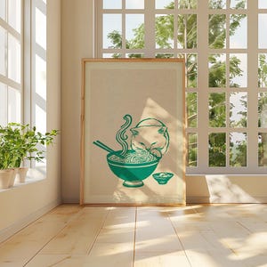 May include: A framed vertical art print featuring a teal-colored illustration of a cat eating noodles from a bowl with chopsticks. The cat is positioned behind the bowl, and a smaller bowl sits to the right. The background is a neutral beige.