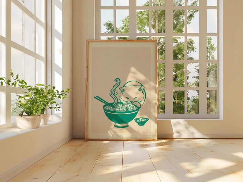May include: A framed vertical art print featuring a teal-colored illustration of a cat eating noodles from a bowl with chopsticks. The cat is positioned behind the bowl, and a smaller bowl sits to the right. The background is a neutral beige.