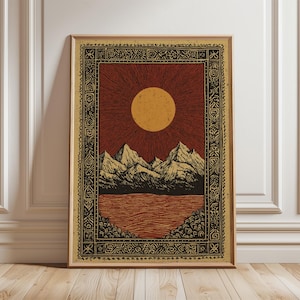 May include: Framed art print depicting a landscape with a sun, mountains, and water. The artwork uses red, yellow, and black tones, with a decorative border. The print is presented in a wooden frame.