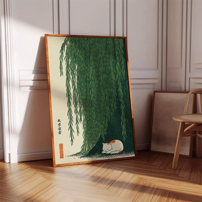 May include: A framed art print featuring a serene scene of a cat resting under a weeping willow tree. The artwork has a traditional Japanese aesthetic, with a color palette of green, cream, and brown. The cat is white with orange markings.