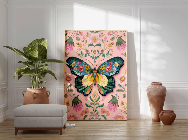May include: A large framed canvas art piece featuring a colorful butterfly design. The butterfly has blue, yellow, and green wings with floral patterns. The background is a pink floral pattern. The artwork is displayed in a room with a plant and a footstool.