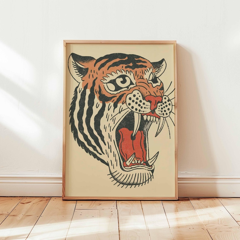 May include: A framed illustration of a tiger's head with its mouth open, showcasing sharp teeth and a red interior. The tiger has orange and black stripes, with a cream-colored background and a wooden frame.