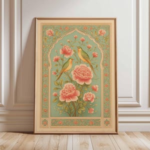 Könnte beinhalten: Gerahmter Kunstdruck mit zwei Vögeln auf einem blühenden Ast mit großen rosa Blüten. Das Kunstwerk hat einen hellgrünen Hintergrund mit einem dekorativen Rahmen und einem Holzrahmen. Der Stil erinnert an Vintage-Botanische Illustrationen.