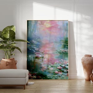 May include: An abstract painting of a water scene with pink and blue hues, framed in gold. A pair of swans floats on the water, surrounded by lily pads. A large potted plant and a gray ottoman are in the foreground.