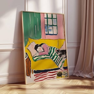 May include: A painting depicting a woman asleep on a yellow sofa with a cat sitting on the sofa. The woman is wearing a pink shirt and a green and white striped blanket. The cat is black and white. The painting is set in a room with a pink wall and a green window.