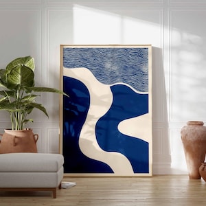 Puede incluir: Impresi&oacute;n art&iacute;stica abstracta en un marco de madera. La obra de arte presenta un dise&ntilde;o con formas azules y blanquecinas. Una gran planta en maceta, un otom&aacute;n gris y jarrones de terracota est&aacute;n en primer plano, creando un dise&ntilde;o interior moderno.