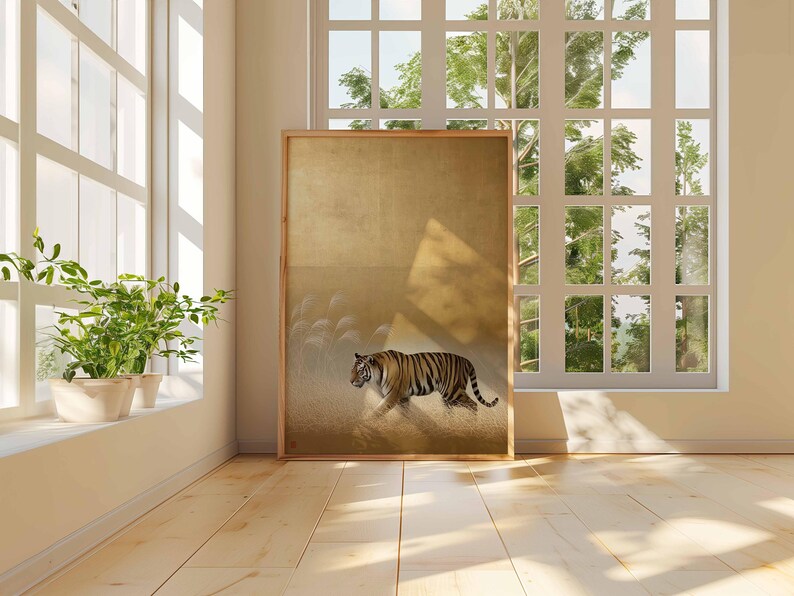 May include: A framed art print featuring a tiger walking across a field. The artwork has a gold background with a tiger in shades of orange, black, and white. The print is displayed in a room with a large window and hardwood floors.