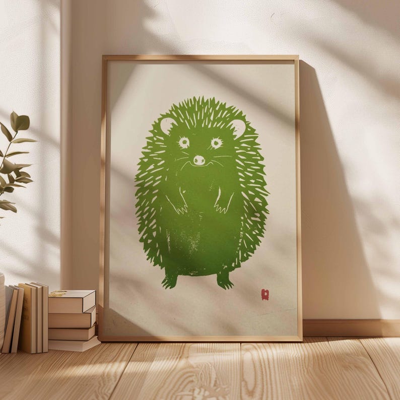 Pu&ograve; includere: Stampa incorniciata con un'illustrazione di un riccio verde. Il riccio &egrave; raffigurato in uno stile semplice, simile alla linoleografia, con un aspetto strutturato. L'opera d'arte &egrave; ambientata su uno sfondo color crema e incorniciata in una cornice di legno chiaro.
