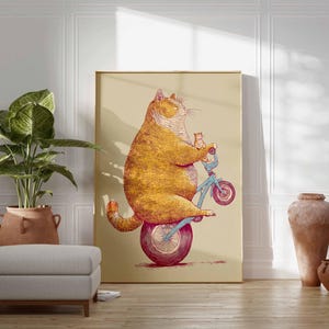 K&ouml;nnte beinhalten: Ein Kunstdruck zeigt eine Illustration einer orangefarbenen Katze auf einem blauen Fahrrad mit einem K&auml;tzchen. Das Kunstwerk ist vor einem beigen Hintergrund in Gold gerahmt. Der Raum umfasst eine Topfpflanze und Terrakotta-Vasen.