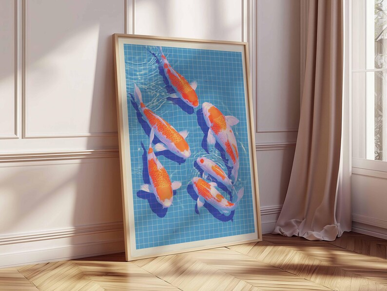 May include: A framed print showing six koi carp in a blue tiled pool. The fish are orange and white. The artwork is displayed on a wooden floor, leaning against a white wall. The frame is light brown.