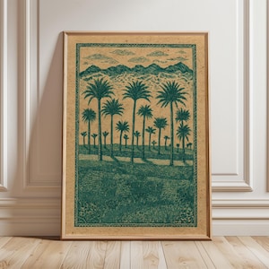 Peut inclure: Impression d'art encadrée représentant un paysage vert et beige. L'œuvre d'art représente des palmiers, des montagnes et des nuages. L'impression est dans un cadre en bois et est appuyée contre un mur blanc et un sol en bois.