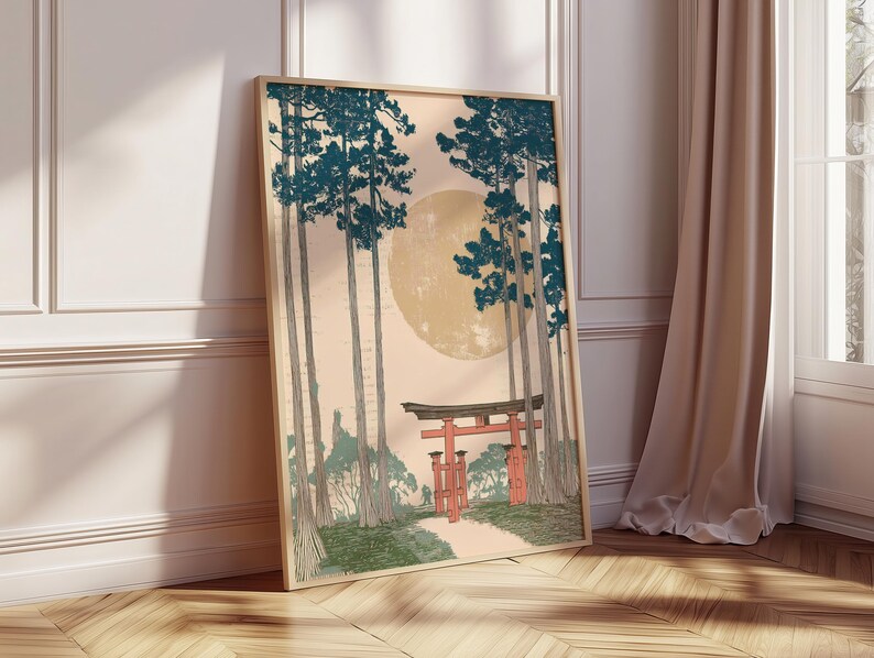 May include: Framed art print featuring a Japanese landscape with tall trees, a large moon, and a red torii gate. The artwork has a vintage aesthetic with a color palette of teal, beige, and red. The print is displayed on a wooden floor.