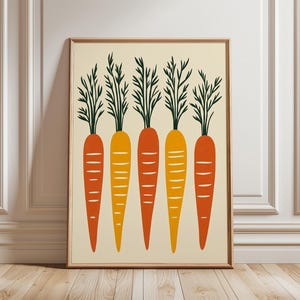 May include: A framed art print depicting five stylised carrots. The carrots are in shades of orange and yellow, with green tops. The background is a light beige, and the frame is brown. The artwork is displayed on a wooden floor.