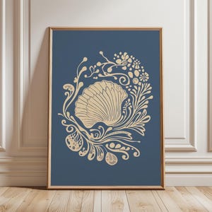 Puede incluir: Impresión enmarcada con un diseño de concha beige sobre un fondo azul oscuro. La concha está rodeada de motivos florales y de hojas. El marco es de color marrón cálido, y la obra de arte se muestra contra una pared blanca y un suelo de madera.