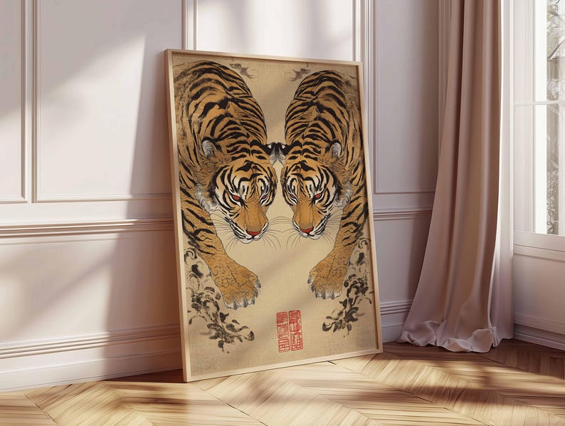 May include: Framed art print featuring two tigers facing each other. The tigers have orange and black stripes, with red eyes and a tan background. The print has a wooden frame and a red stamp in the lower right corner.