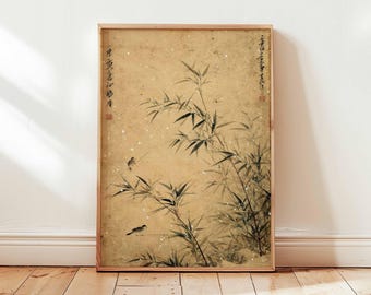 Puede incluir: Una impresión enmarcada de una pintura de estilo asiático con tallos de bambú y dos pequeños pájaros. La obra de arte está en tonos de negro, blanco y beige, con texto en las esquinas superiores. El marco es de color marrón claro.