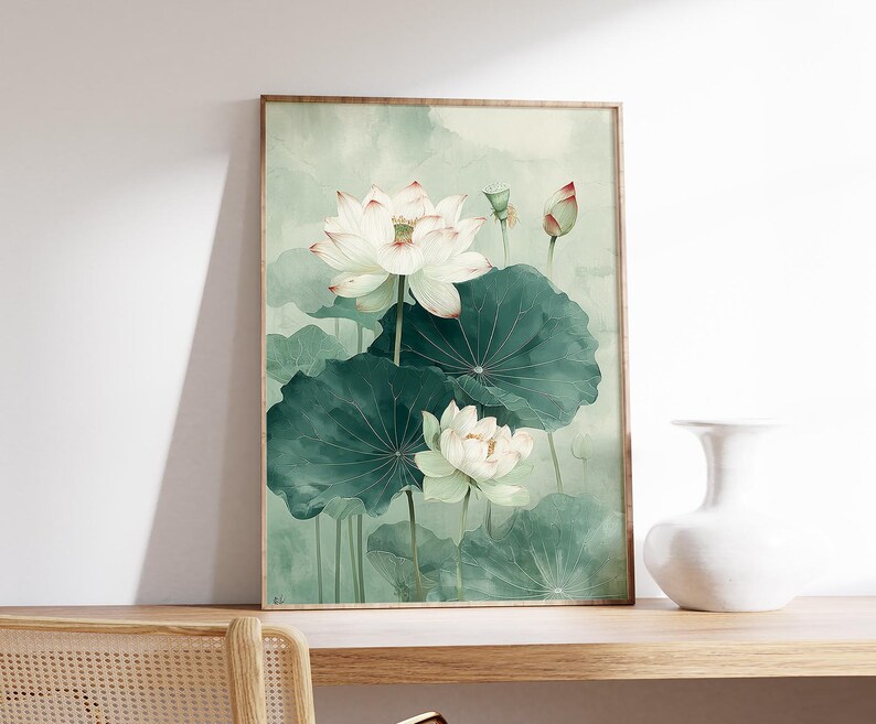 Puede incluir: Una impresi&oacute;n art&iacute;stica enmarcada que presenta una pintura de acuarela de flores de loto blancas con hojas verdes. La obra de arte tiene una paleta de colores suaves y apagados con tonos de verde y blanco, creando una est&eacute;tica serena y natural.