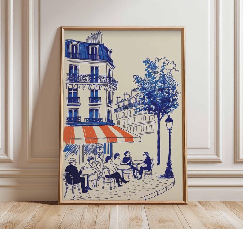 K&ouml;nnte beinhalten: Ein gerahmter Kunstdruck, der eine Pariser Caf&eacute;szene darstellt. Die Illustration zeigt ein Geb&auml;ude mit blauem Dach und Fenstern, eine orange-wei&szlig; gestreifte Markise und Personen, die an Tischen sitzen. Ein Baum und eine Stra&szlig;enlaterne sind ebenfalls enthalten.