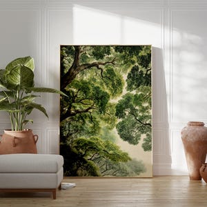 May include: A large framed art print of a tree canopy in shades of green and brown. The artwork is leaning against a white wall, next to a potted plant, a footstool, and two terracotta vases. The room has a natural, earthy aesthetic.