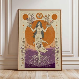 Op de afbeelding: Een ingelijste kunstdruk met een vrouw met lang haar die planten vasthoudt. Het kunstwerk heeft een oranje zon- en maanontwerp, met paarse en beige tinten. De jurk van de vrouw heeft bloemmotieven en boomwortels staan onderaan.