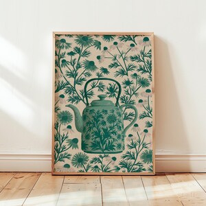 Puede incluir: Una impresión de arte mural rectangular que presenta una tetera de color verde azulado centrada sobre un fondo de flores repetitivas de color verde oscuro y blanco similares a las margaritas sobre un lienzo beige claro. La tetera tiene el mismo patrón.