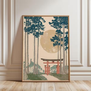 May include: Framed art print featuring a Japanese landscape with a red torii gate, tall trees, and a large yellow sun. The artwork has a vintage aesthetic with muted colors and a serene atmosphere. The print is displayed in a wooden frame.