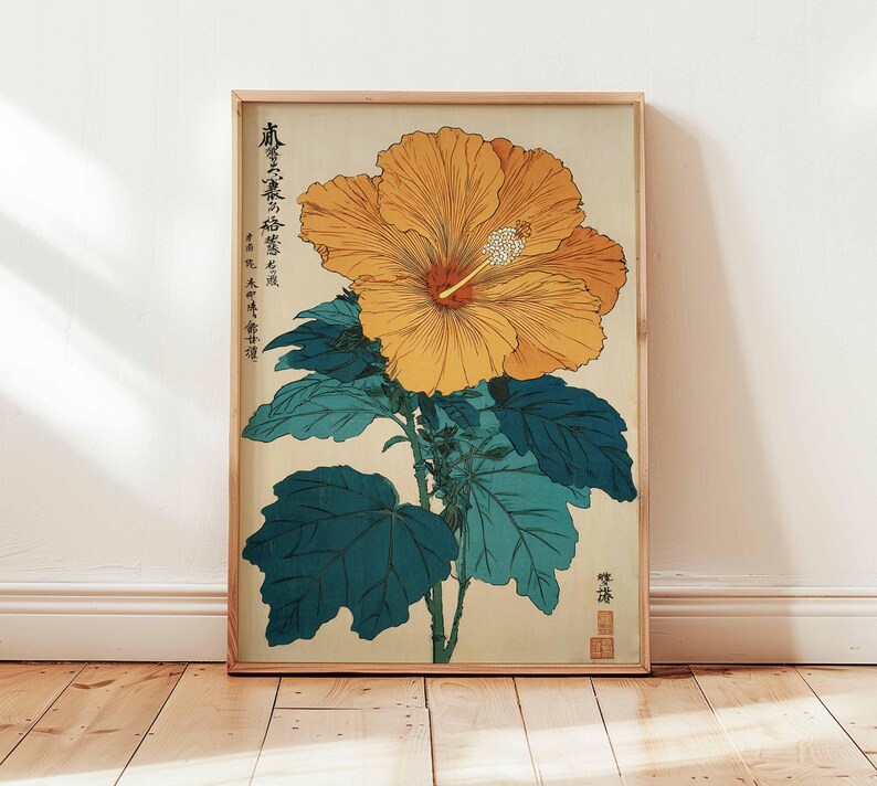May include: A framed botanical print depicting a large, yellow hibiscus flower with a red centre and white stamen. The flower is set against a cream background with teal leaves and stems. The print has Japanese text and is in a wooden frame.