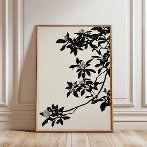 May include: A framed art print with a black and white botanical illustration. The artwork shows a branch with leaves and flowers against a cream background. The frame is made of wood.