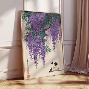 May include: A framed art print featuring a Japanese-style illustration of wisteria blossoms in shades of purple and green. A child is reading a book, with birds and butterflies nearby. The artwork is set against a cream background.