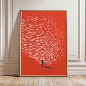 May include: Framed art print featuring a minimalist design. A silhouetted figure stands on a red background, facing a swirling pattern of white shapes. The artwork is encased in a wooden frame, adding a touch of warmth to the modern aesthetic.