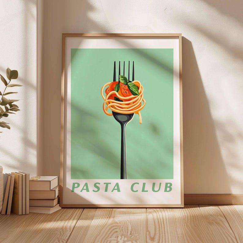 Op de afbeelding: Een ingelijste kunstafdruk met een zwarte vork met spaghetti, tomaat en basilicum. De pasta is kunstzinnig gerangschikt op de vork tegen een lichtgroene achtergrond. De tekst "PASTA CLUB" staat onderaan.