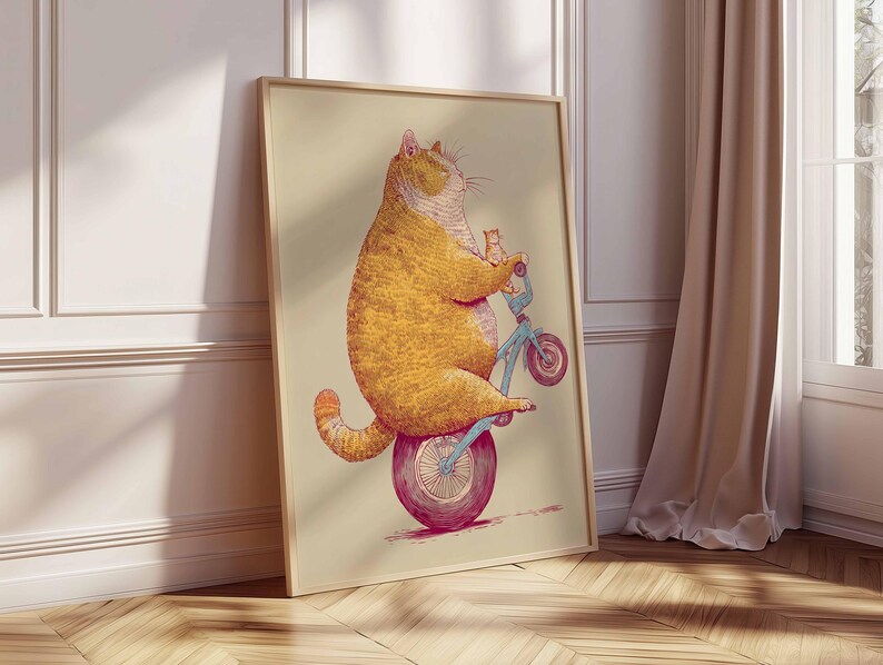 K&ouml;nnte beinhalten: Gerahmter Kunstdruck mit einer Illustration einer gro&szlig;en, orangefarbenen Katze, die auf einem blauen Fahrrad mit einem kleinen K&auml;tzchen f&auml;hrt. Die Katze sitzt auf einem gro&szlig;en, pinkfarbenen Rad. Das Kunstwerk hat einen hellbeigen Hintergrund.