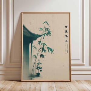 Puede incluir: Impresión artística enmarcada con una escena de inspiración asiática. La obra representa un tejado verde oscuro, tallos de bambú y un pequeño árbol en maceta sobre un fondo crema. Incluye texto vertical negro.