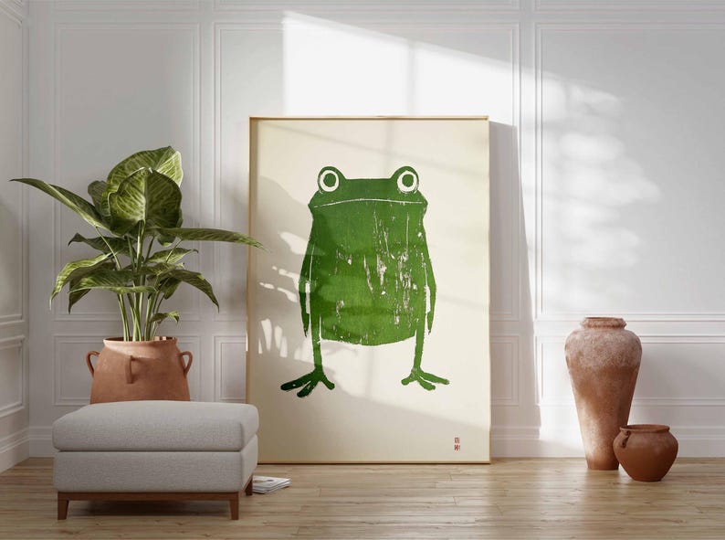 May include: A framed print of a green frog with a textured, distressed look. The frog is centered on a white background.