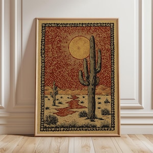 Puede incluir: Impresión artística enmarcada que representa un paisaje desértico con un gran cactus, un sol poniente y un río sinuoso. La obra de arte utiliza tonos marrones, beige y rojos, con un borde decorativo. La impresión se muestra en un marco de madera.