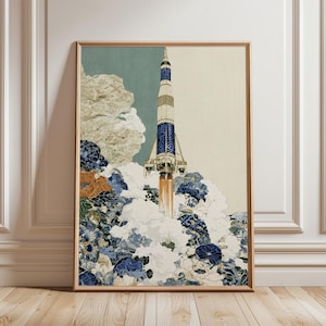 May include: A framed vertical art print featuring a rocket ship launching upwards. The rocket is decorated with blue and white floral patterns. Below the rocket, large white and blue stylised clouds and floral motifs billow outwards.