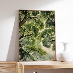 May include: A framed art print featuring a watercolor painting of a forest canopy. The artwork showcases lush green foliage and tree branches, with a soft, diffused light filtering through the leaves. The print is displayed on a wooden shelf.