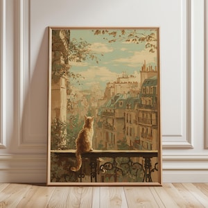 May include: A framed art print depicts a ginger cat perched on a balcony, gazing out at a cityscape. The artwork features a muted color palette with buildings, trees, and a cloudy sky. The print is in a wooden frame.