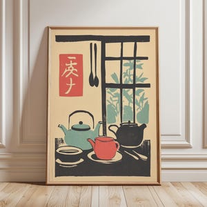 以下が含まれることがあります： 日本のスタイルの静物画が描かれた額入りのプリント。 ティーポットとカップがティール、赤、黒で描かれ、背景に窓があります。 日本語の文字が入った赤い正方形も含まれています。