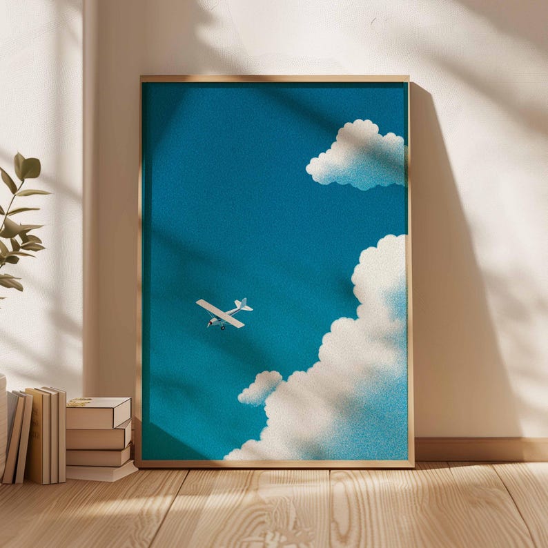 Peut inclure: Une affiche encadr&eacute;e repr&eacute;sentant un petit avion blanc volant dans un ciel bleu vif avec des nuages blancs. L'&oelig;uvre d'art a un aspect textur&eacute; et est expos&eacute;e dans une pi&egrave;ce avec de la lumi&egrave;re naturelle et un sol en bois.