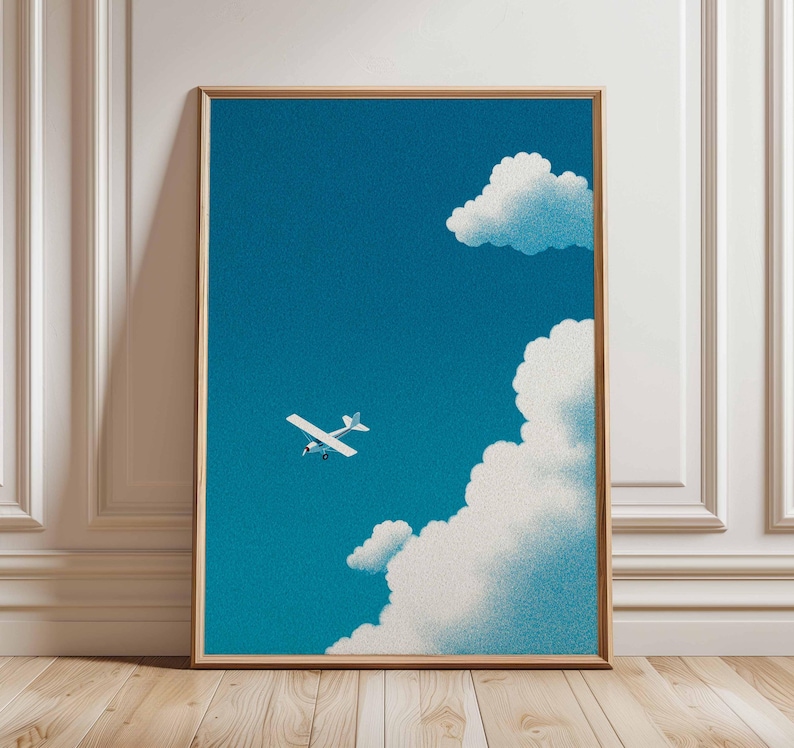 Peut inclure: Une affiche encadr&eacute;e repr&eacute;sentant un petit avion blanc volant dans un ciel bleu vif parsem&eacute; de nuages blancs et duveteux. L'&oelig;uvre d'art a un aspect textur&eacute; et granuleux, et est encadr&eacute;e en bois.
