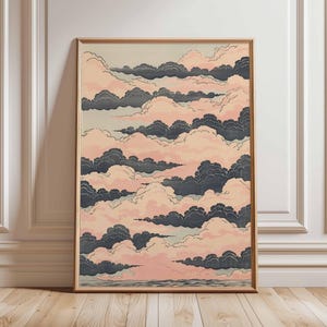 May include: A framed art print featuring a stylized depiction of clouds. The artwork showcases layers of dark gray and pink clouds against a light background. The print is in a wooden frame, adding a touch of warmth to the piece.