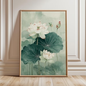 Puede incluir: Una impresi&oacute;n en acuarela enmarcada con flores de loto blancas y grandes hojas verdes sobre un fondo verde suave y apagado. La obra de arte tiene un tema natural y bot&aacute;nico, con un enfoque en los delicados detalles de las flores y el follaje.