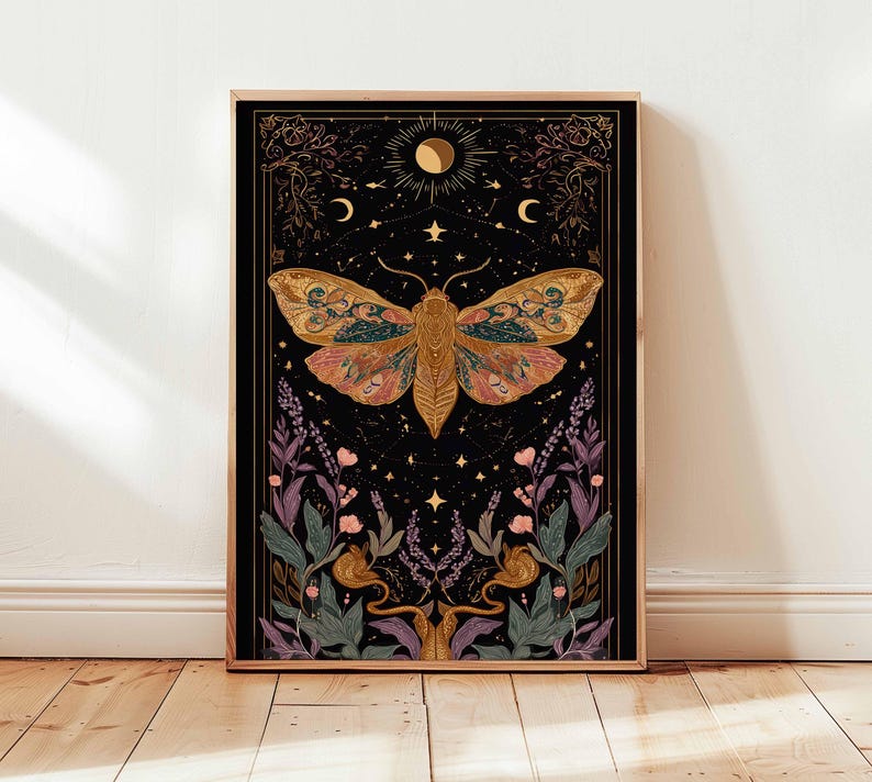 May include: A framed art print featuring a detailed illustration of a moth with intricate wing patterns in shades of gold, pink, and teal against a black background. The artwork includes celestial elements like stars, moons, and suns, with floral and botanical accents.