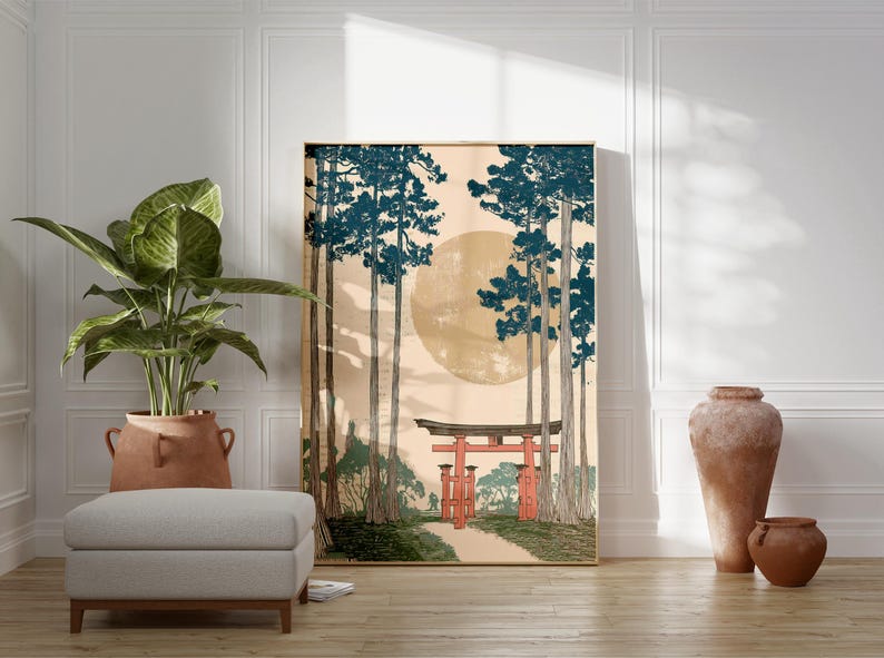 May include: A framed art print depicting a Japanese landscape with tall trees, a large sun, and a red torii gate. The artwork has a vintage aesthetic, with a neutral color palette and a touch of blue and red.
