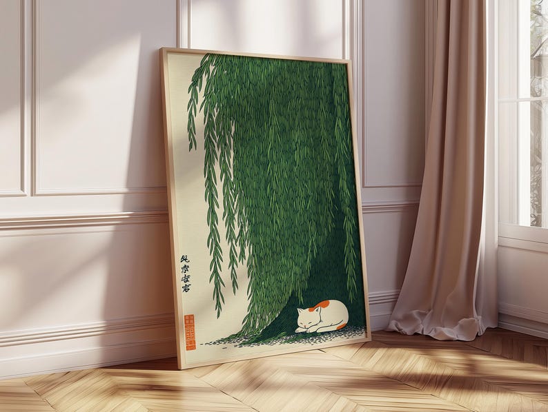 May include: A framed art print featuring a Japanese-style illustration. The artwork depicts a green weeping willow tree with a white and orange cat resting beneath its branches. The print has Japanese text and a red seal.