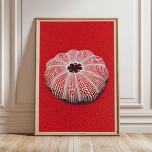 May include: A framed art print showcasing a large, stylised floral design in white and red dots, set against a textured red backdrop. The artwork is presented in a wooden frame. The piece has a modern aesthetic and would make a striking addition to any room.