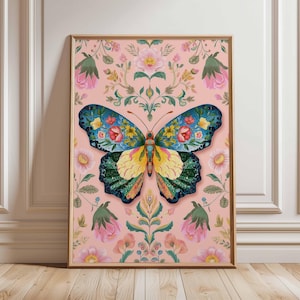 May include: A framed art print featuring a colorful butterfly with floral patterns. The butterfly has blue, yellow, and green wings, set against a pink background with floral and leaf motifs. The artwork is in a wooden frame.